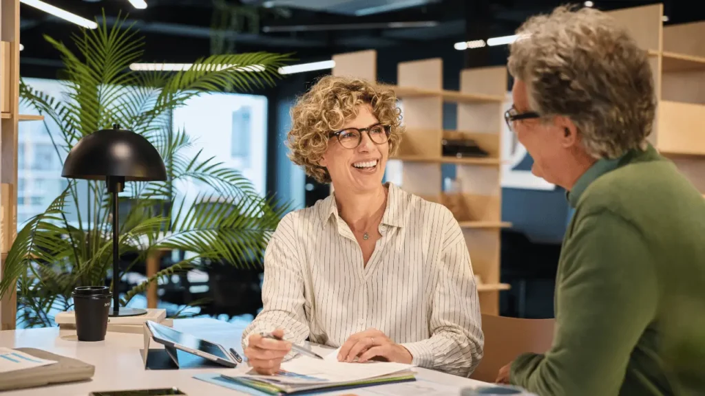 img b relatorio de transparencia salarial esg plurie br Duas mulheres conversando em ambiente de trabalho